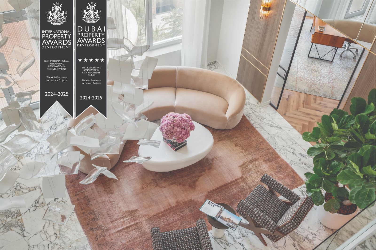 The Viola Penthouse living room seen from above, with a curved blush sofa, marble floors and a suspended glass sculpture, and its 2024–2025 International Property Awards and Dubai Property Awards ribbons